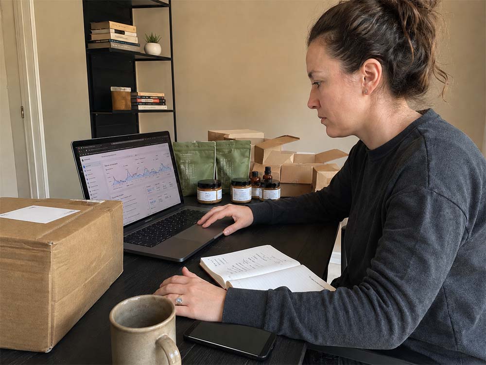 Small online retail team packing orders while reviewing ecommerce SEO and product performance data