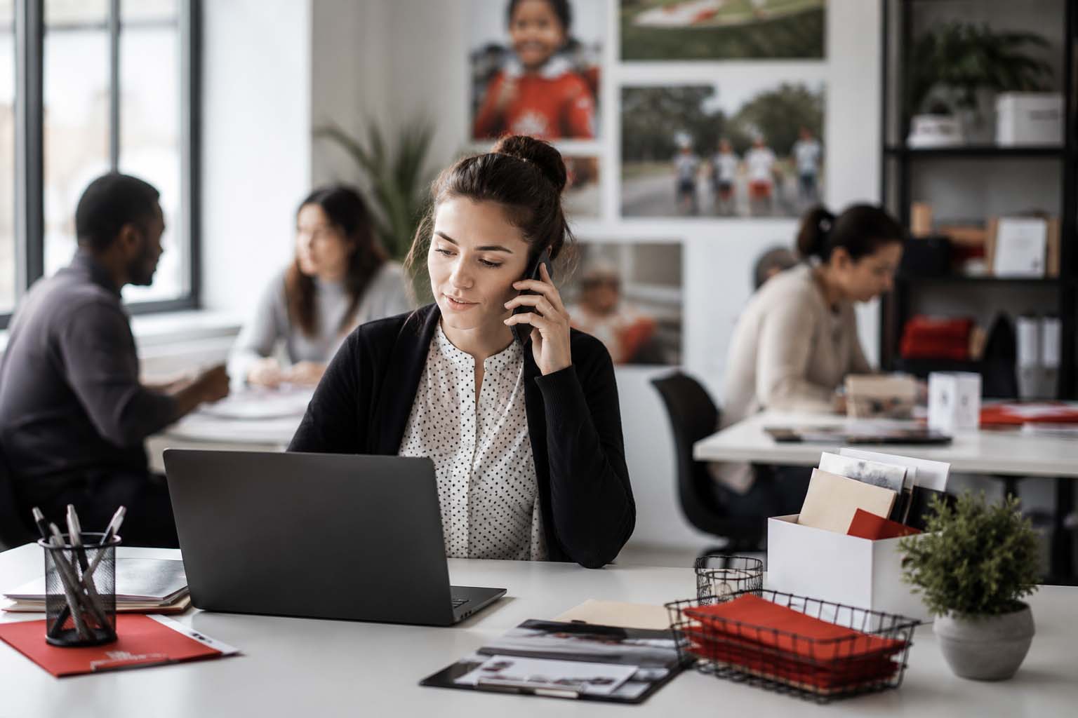 Charity team office scene with a professional woman on the phone planning nonprofit SEO and supporter campaign work.